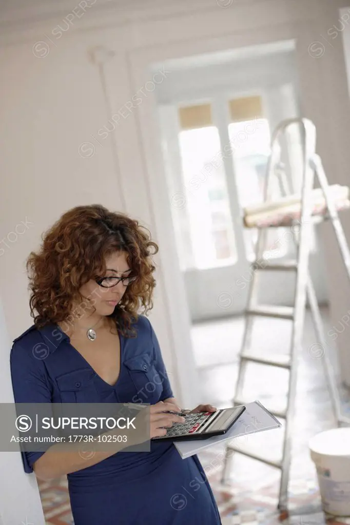 Woman using calculator in room