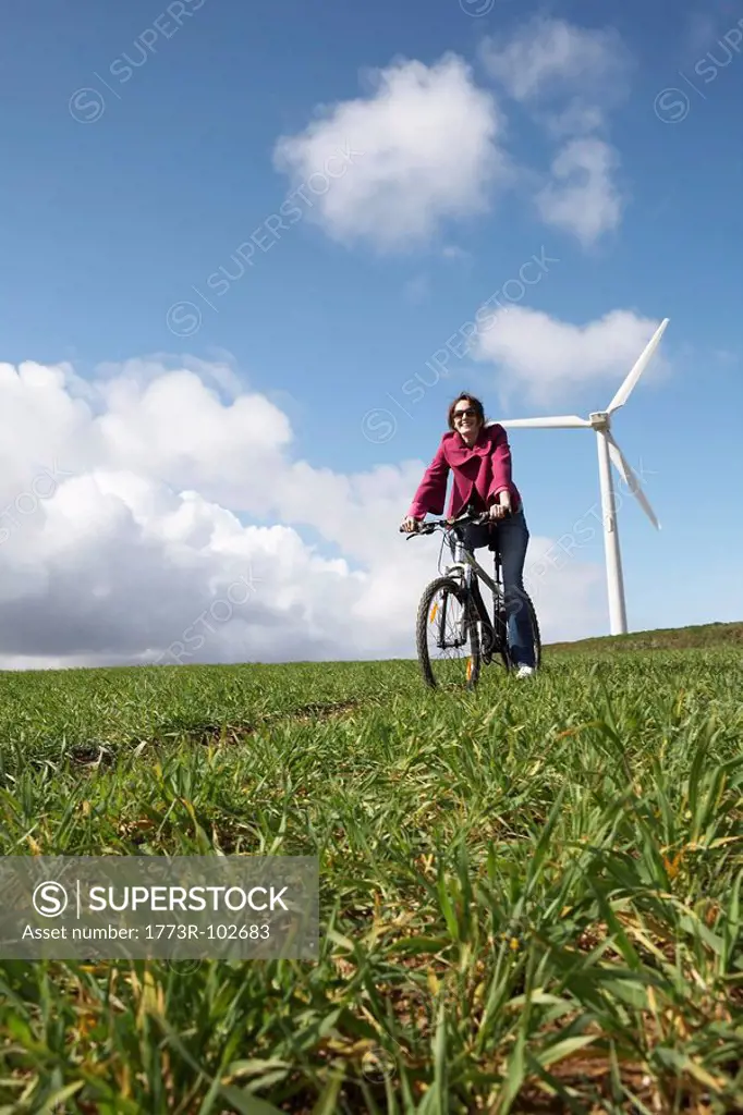 Woman riding a bike on a wind farm