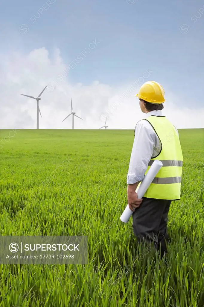 Man holding plans on a wind farm