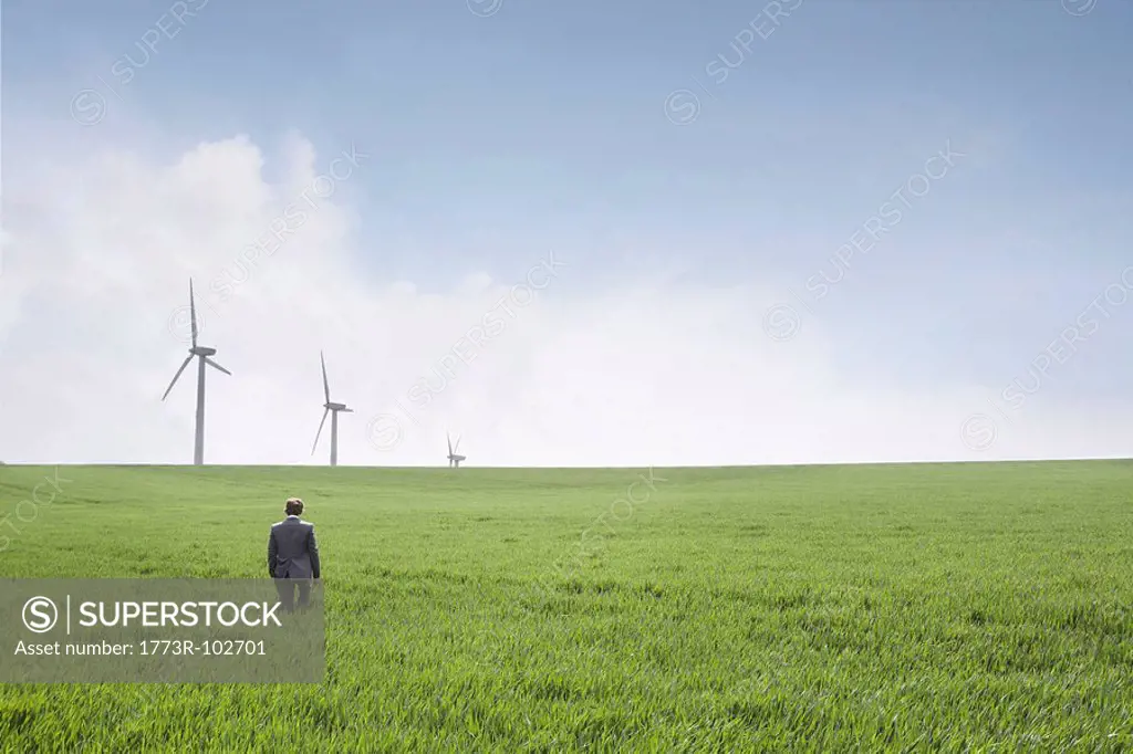 Man walking towards wind turbines