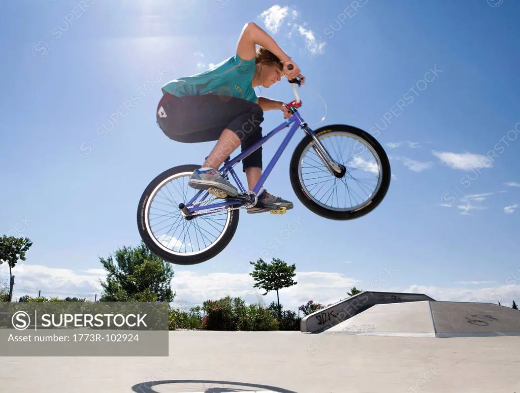 Teen boy on bike jumping