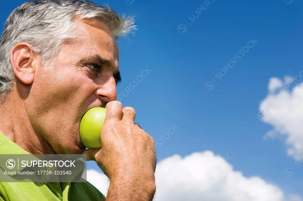 Man biting into apple