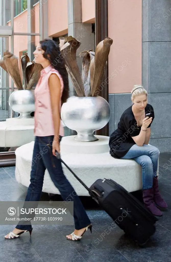 Women with luggage and cellular phone
