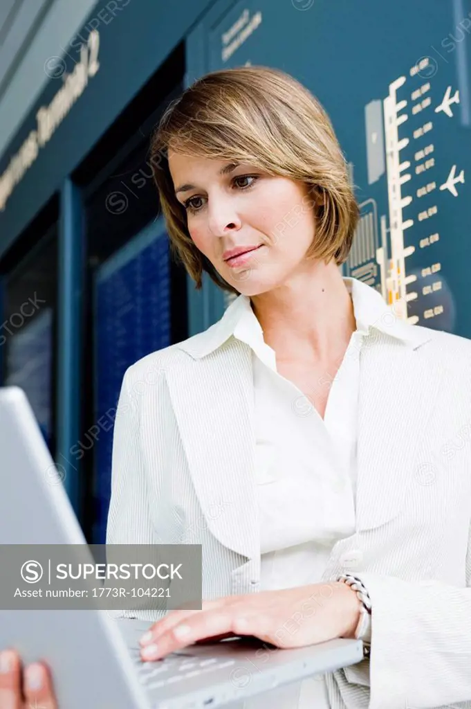 Woman holding up a laptop working