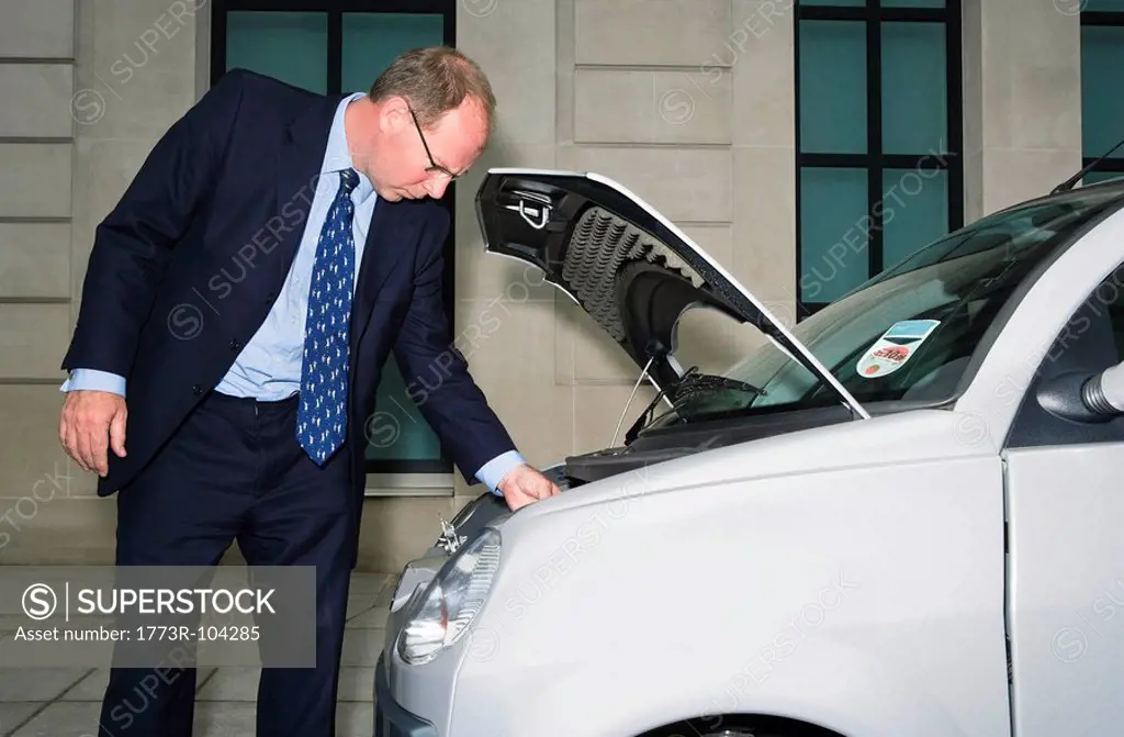 Man looking at engine of electric car