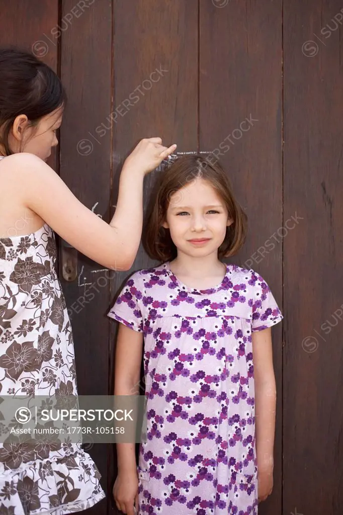 Young girls measuring themselves