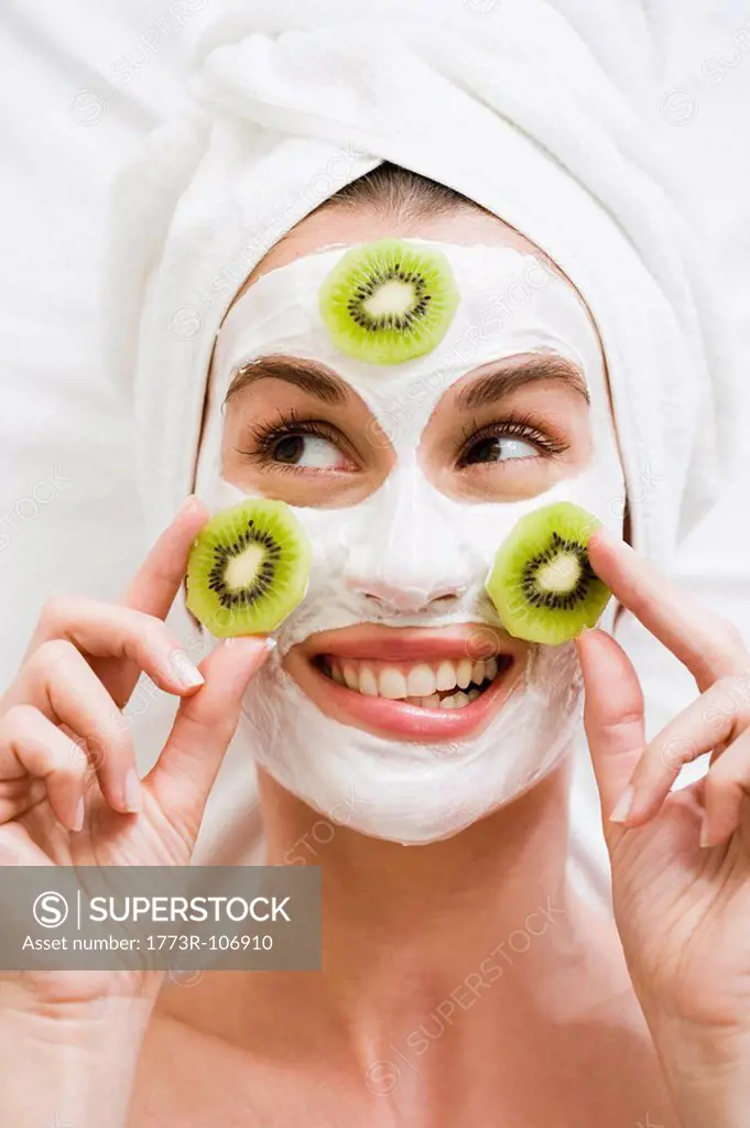 Woman with face mask and kiwi fruit