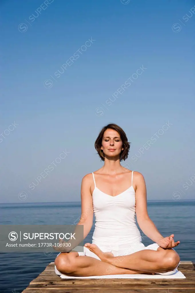 Woman doing yoga on a pier