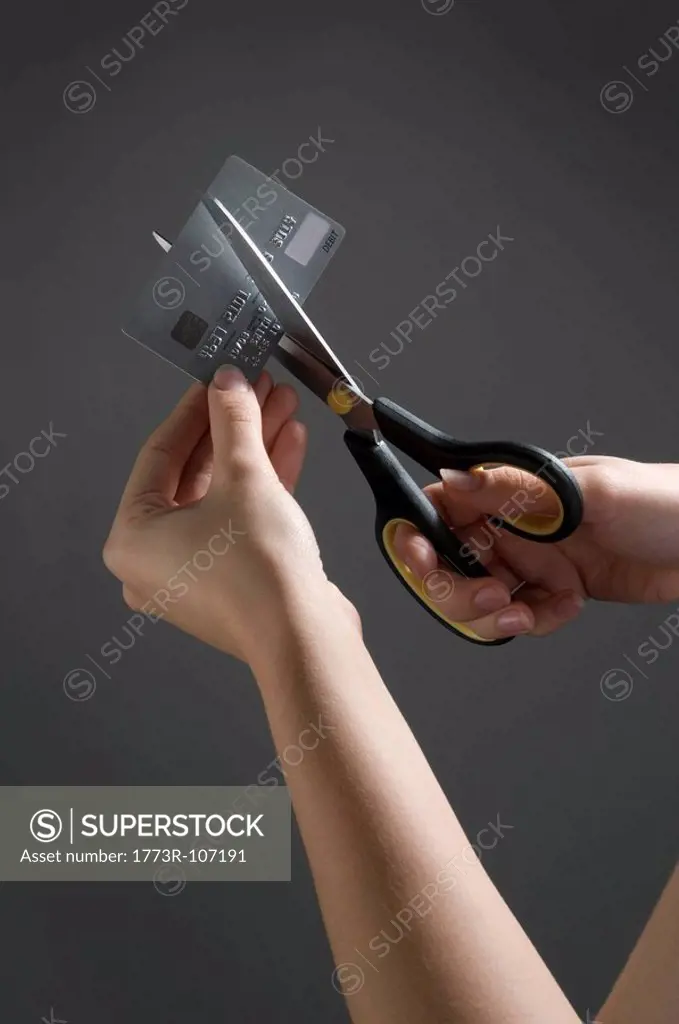 Female hands cutting credit card