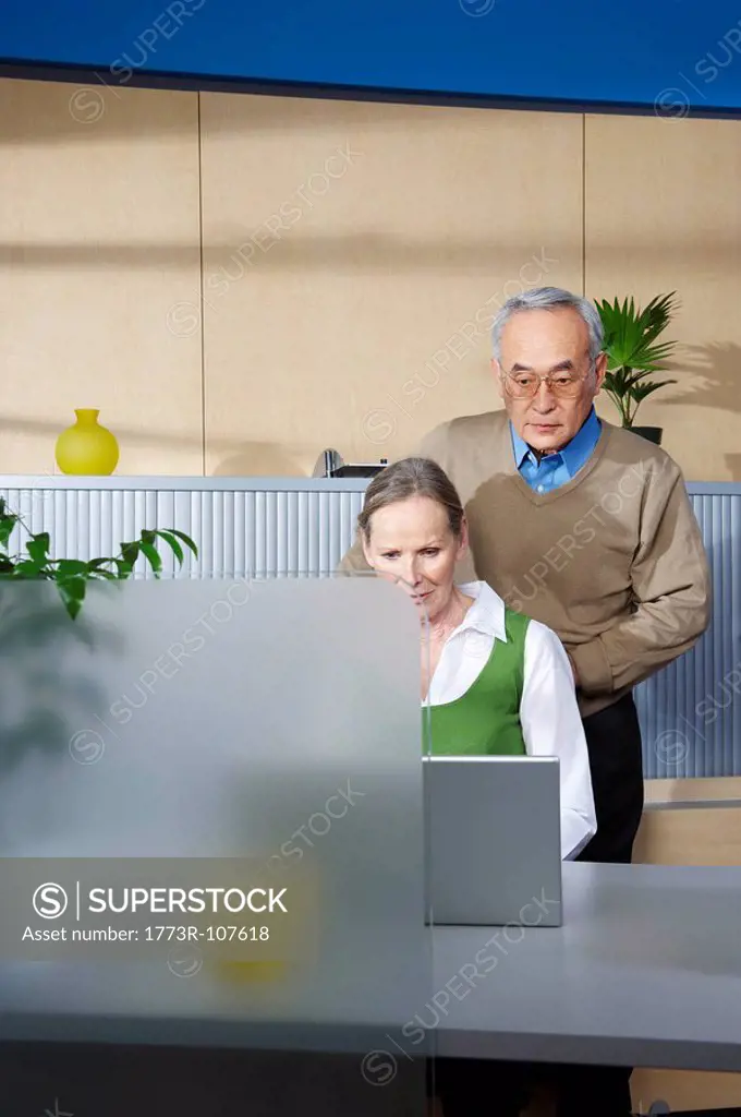 Senior man and woman by office desk