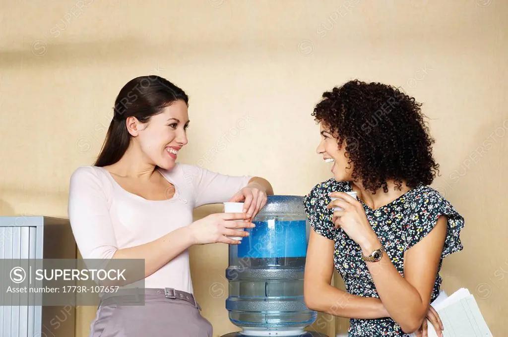 Two women laughing by water cooler