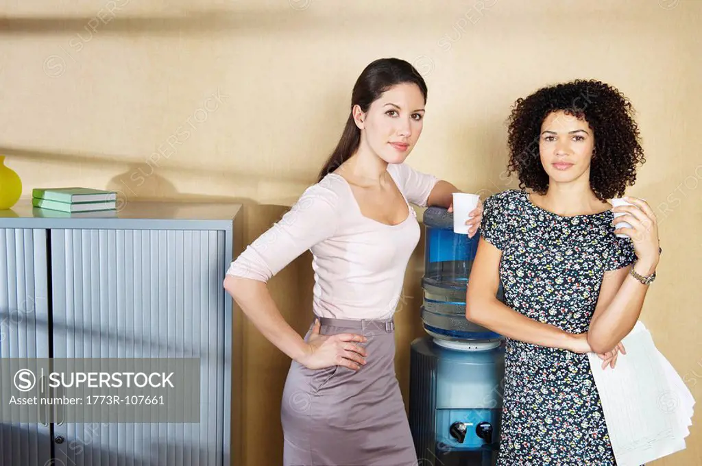 Two women standing by water cooler
