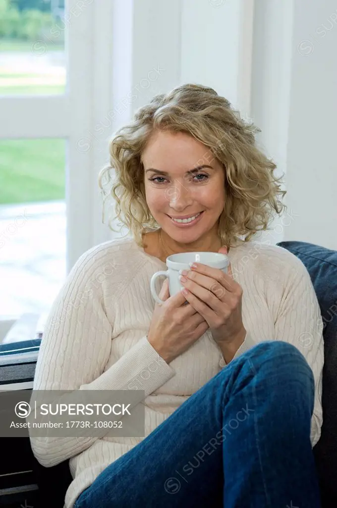 Woman on sofa with cup/mug