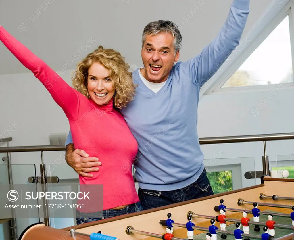Couple having fun playing table football