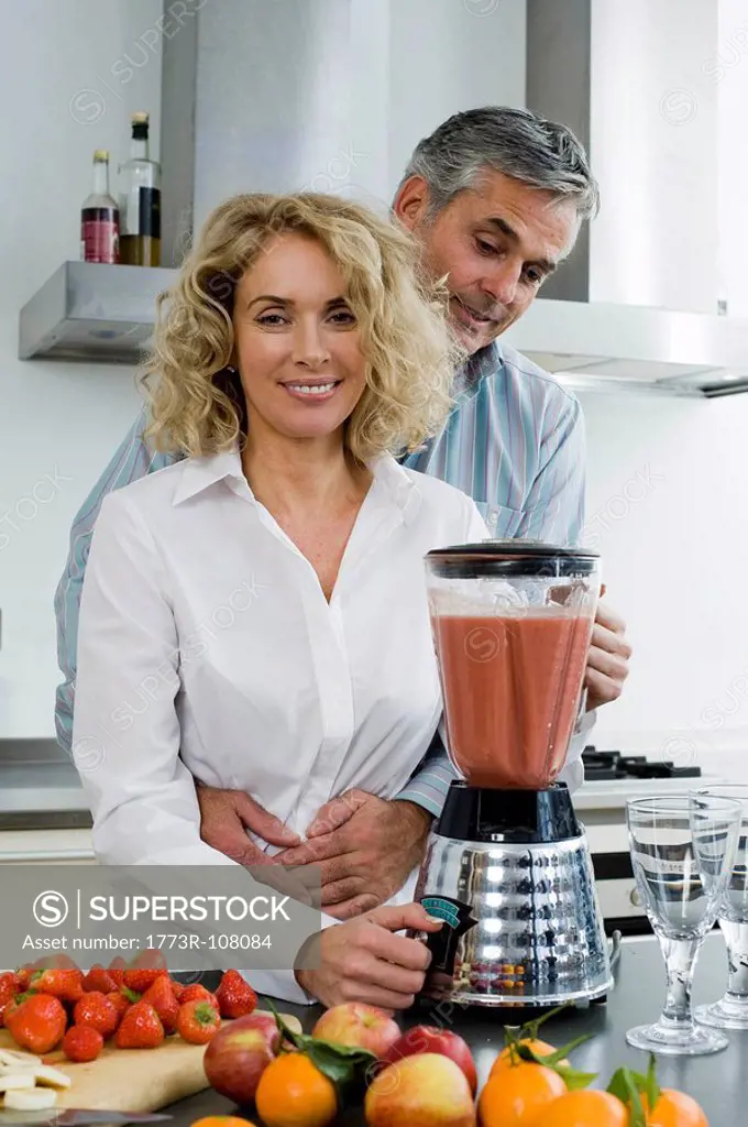 Man and woman preparing healthy drink