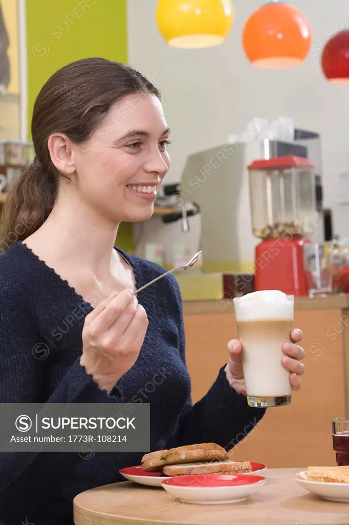Young woman with latte, laughing