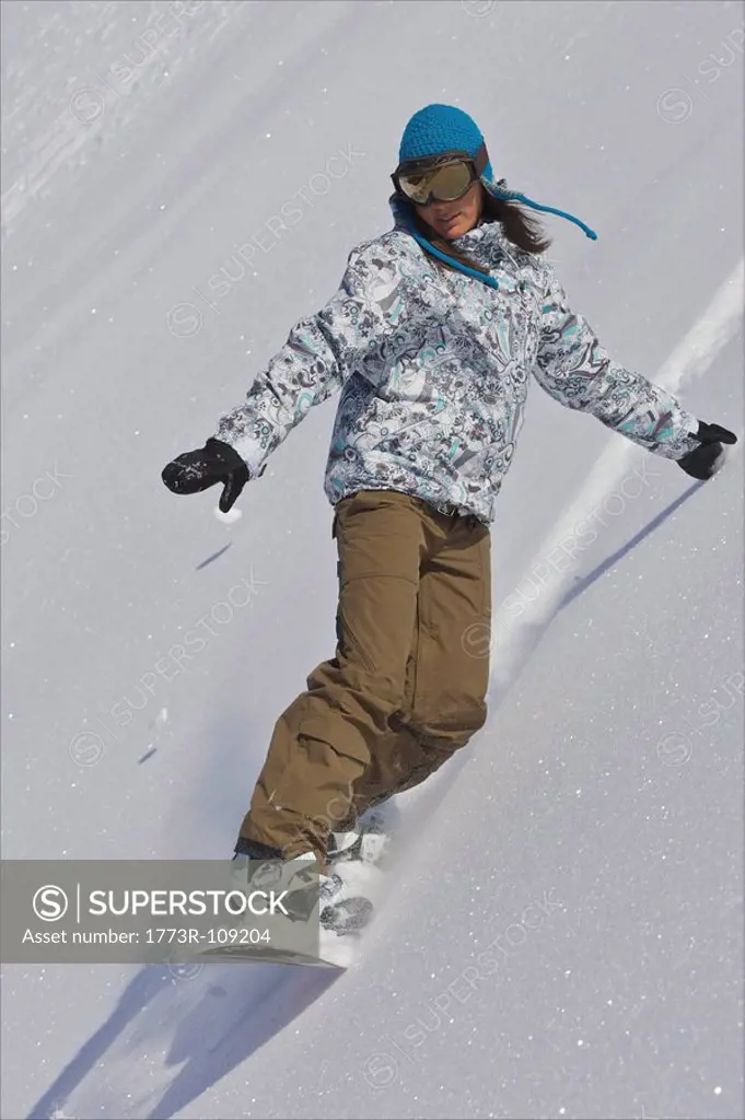 Female snowboarder turning off piste