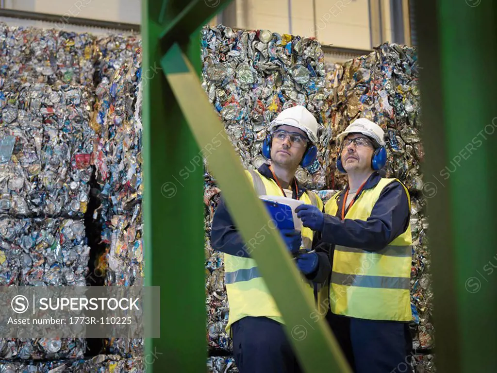 Recycle Workers With Bales Of Tin Cans