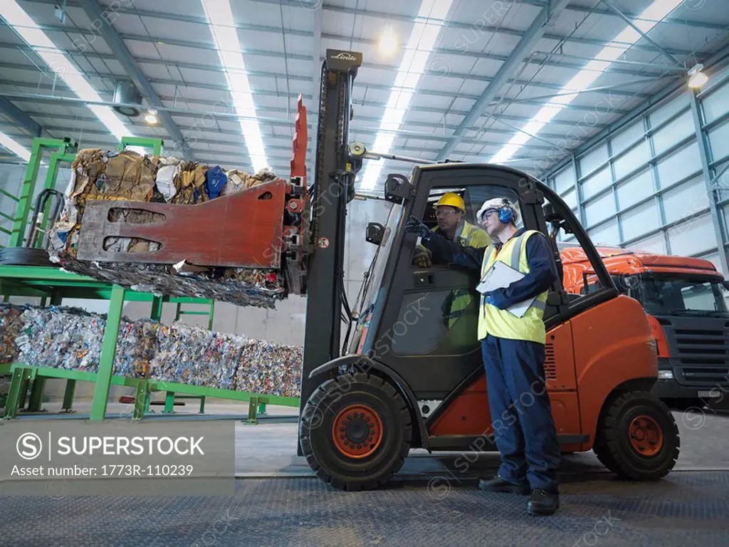Workers And Forklift Truck In Plant