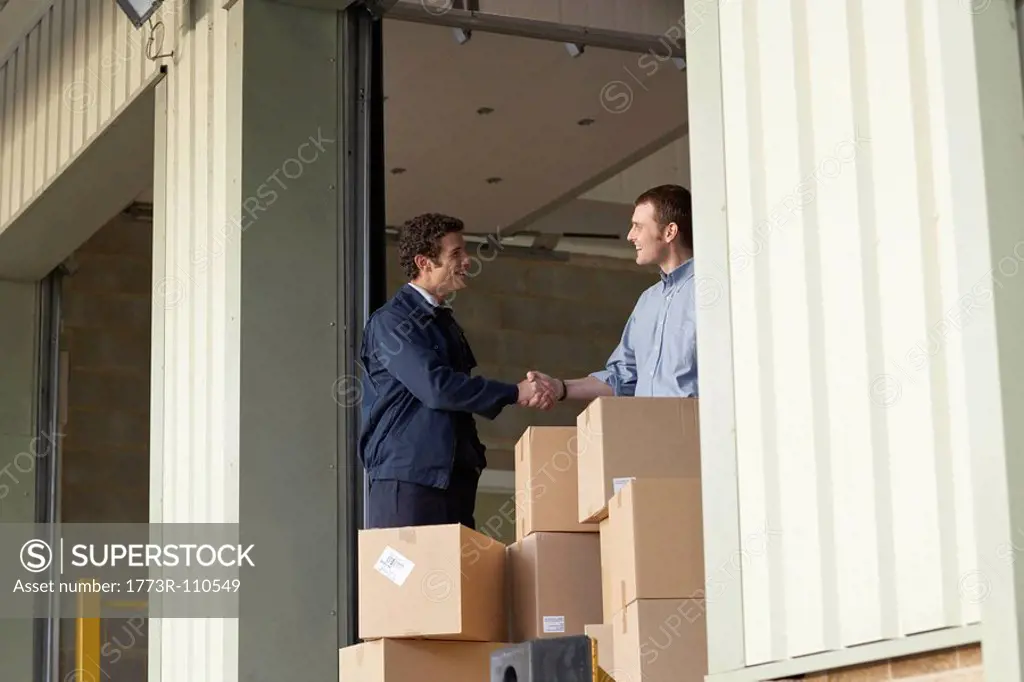 Businessman and worker in warehouse