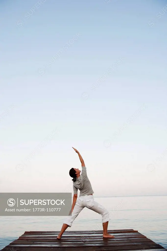 Young Woman Doing Yoga At Jetty