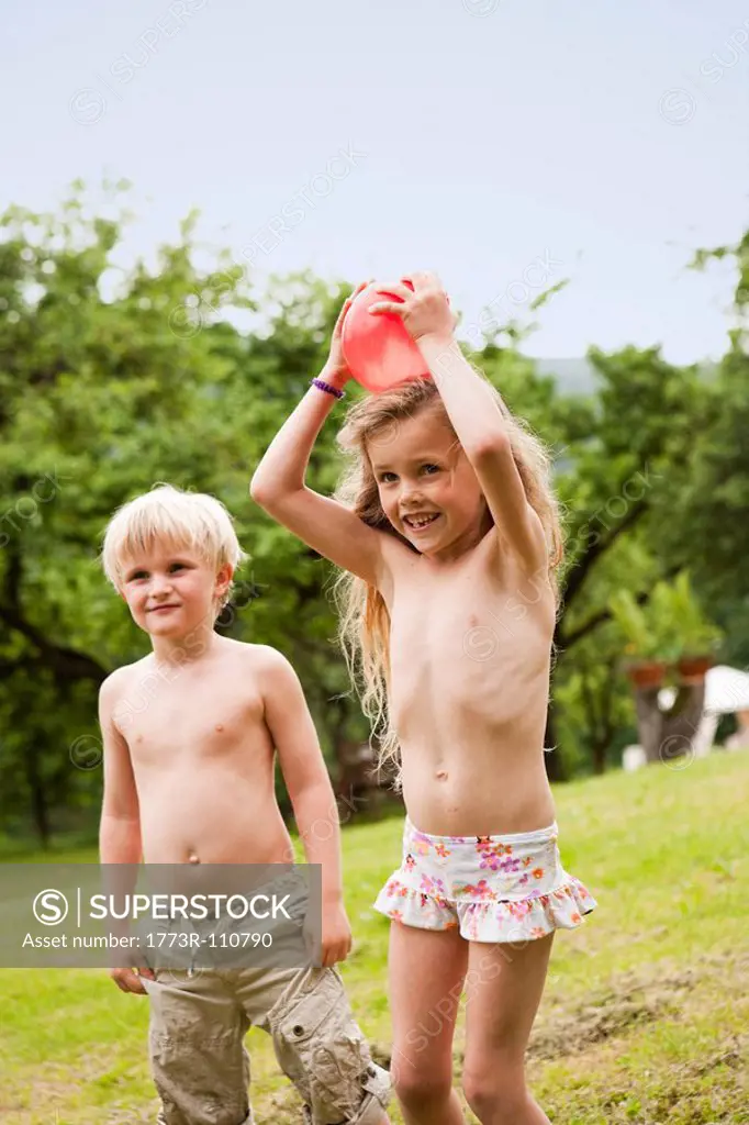 Young Boy And Girl Playing in Garden