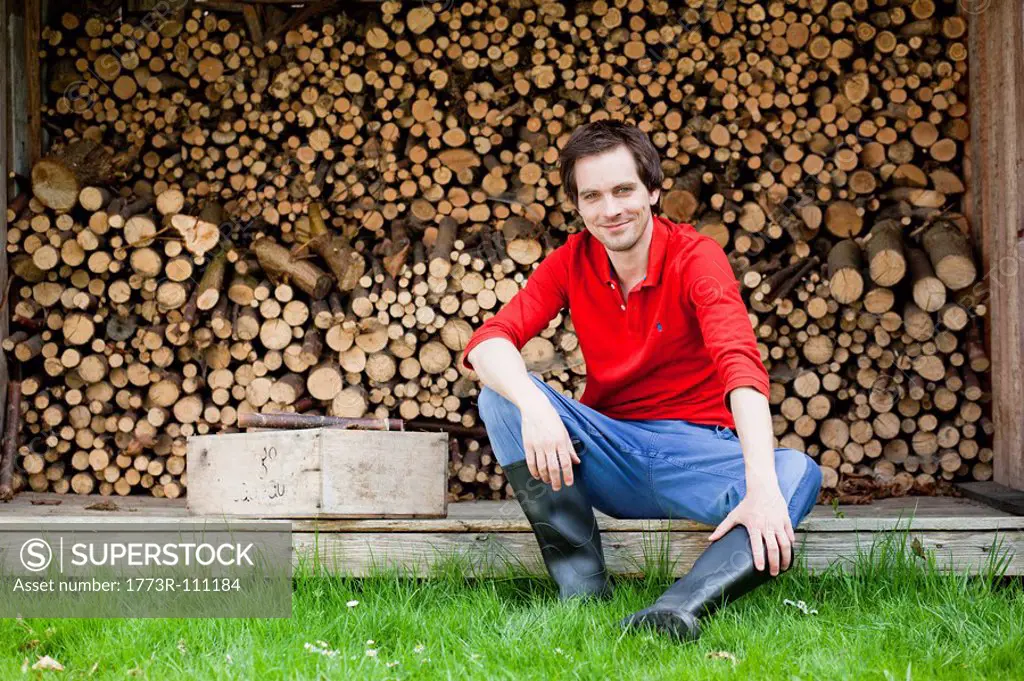 man sitting in front of haystack