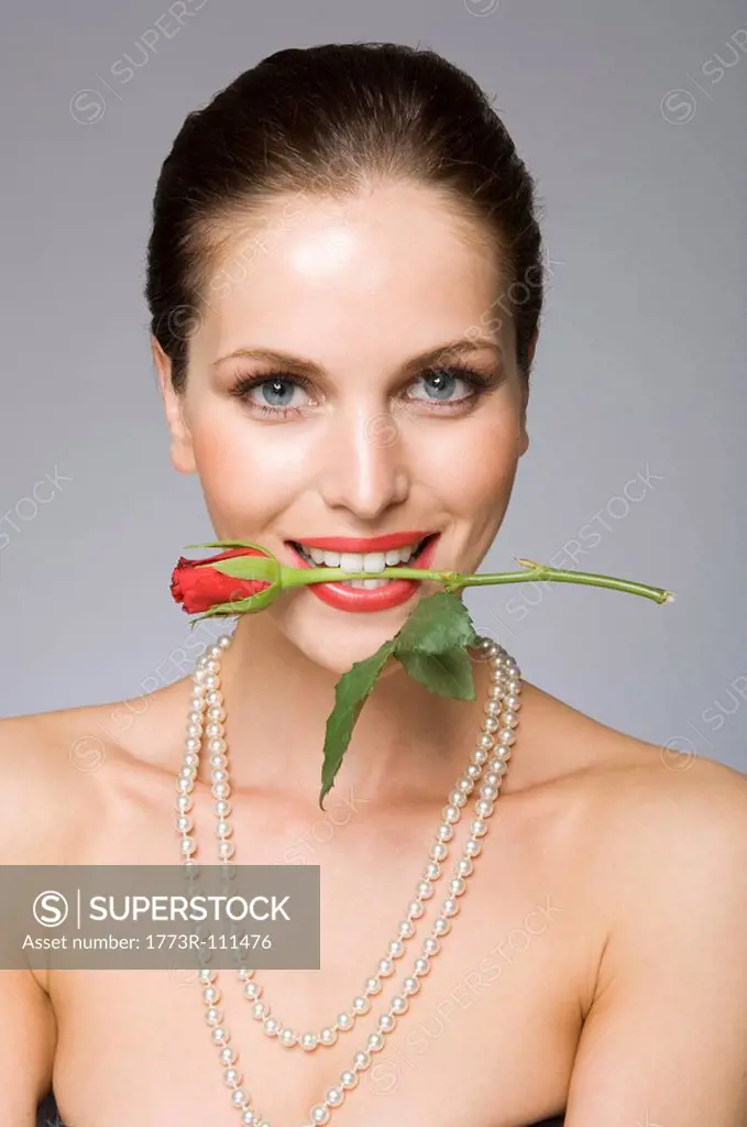 Female beauty model rose in mouth
