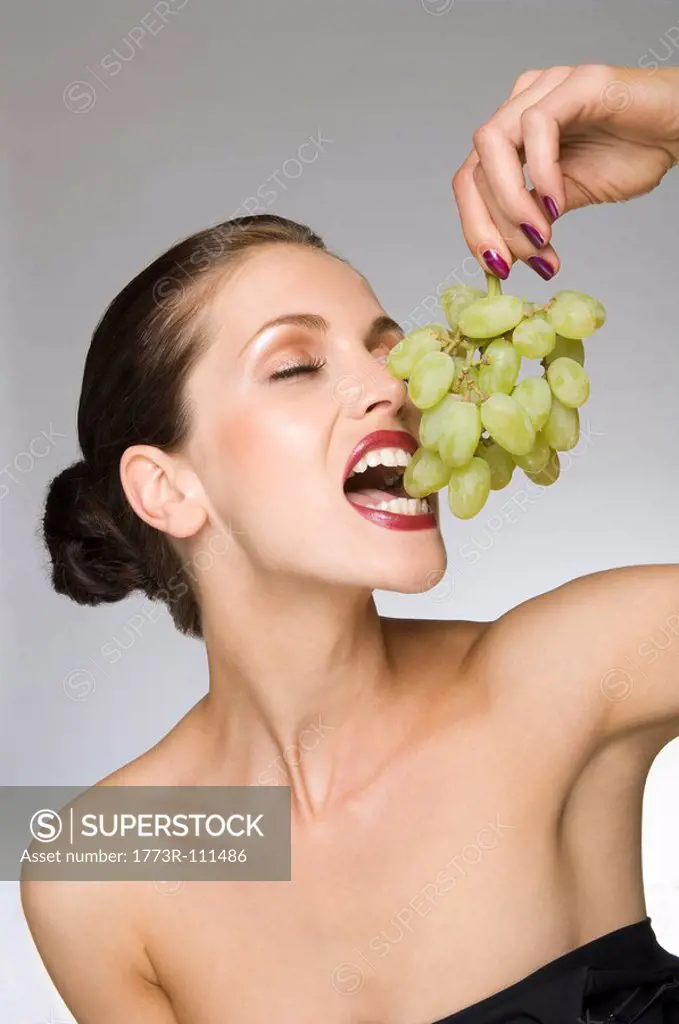 female beauty eating grapes