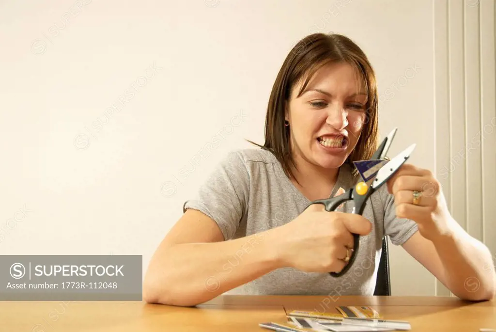 woman cutting credit cards
