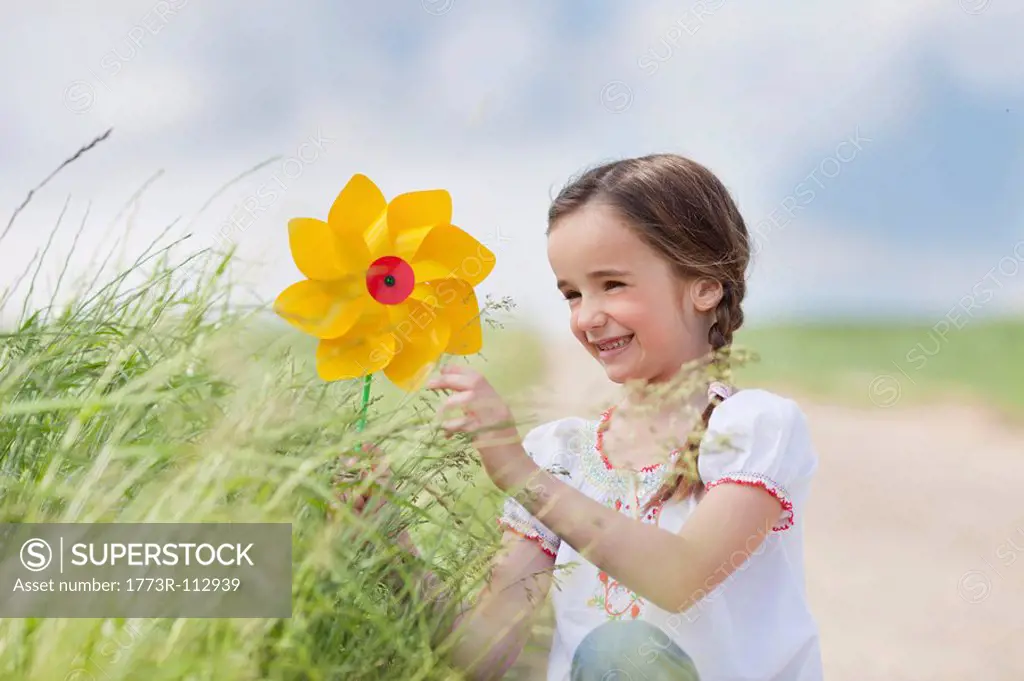 young girl playing with toy windmill
