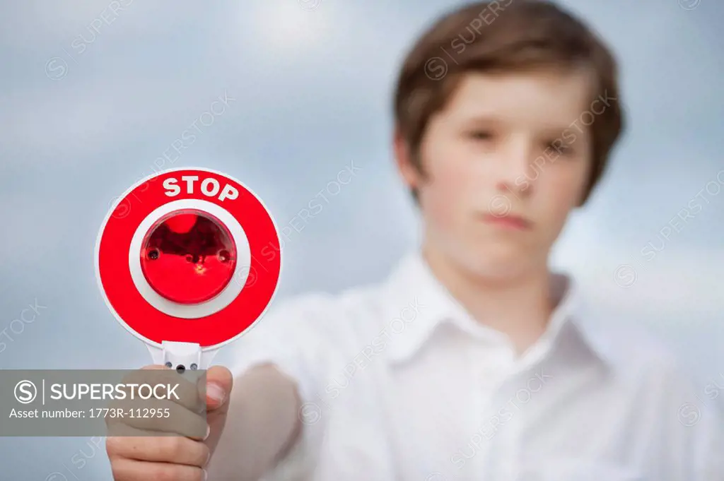young boy holding up stop sign