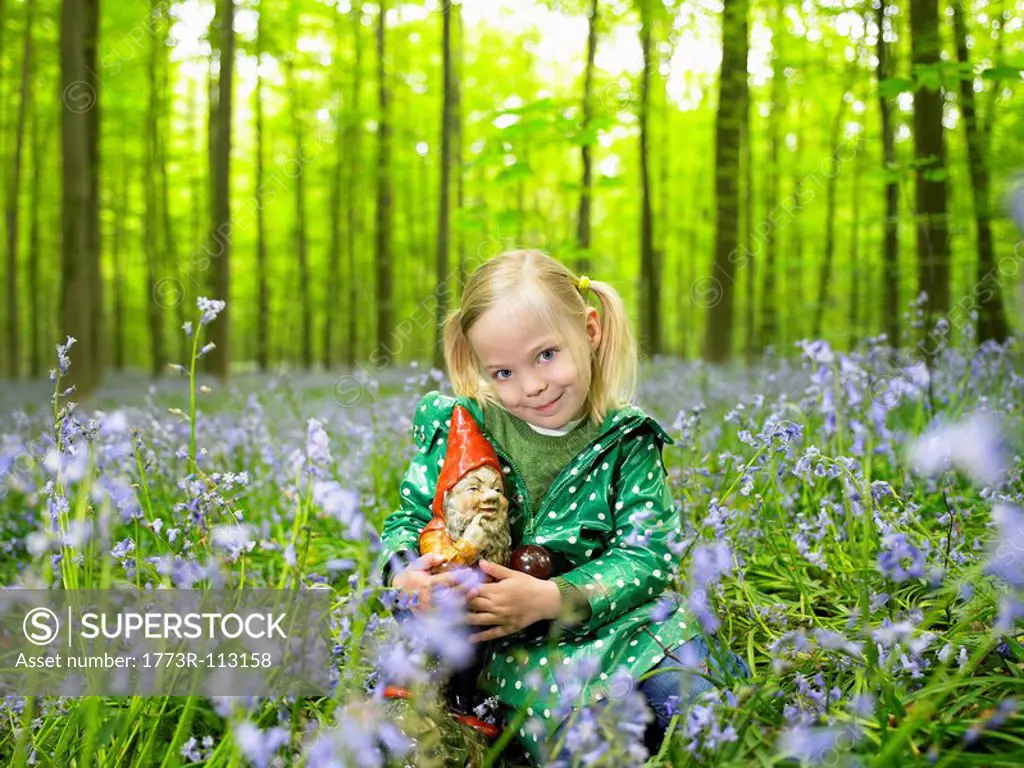 Girl with a garden gnome, in the woods