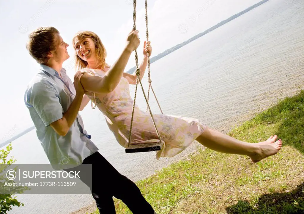 woman and man kissing on swing