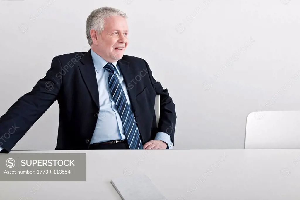 man sitting, smiling at desk