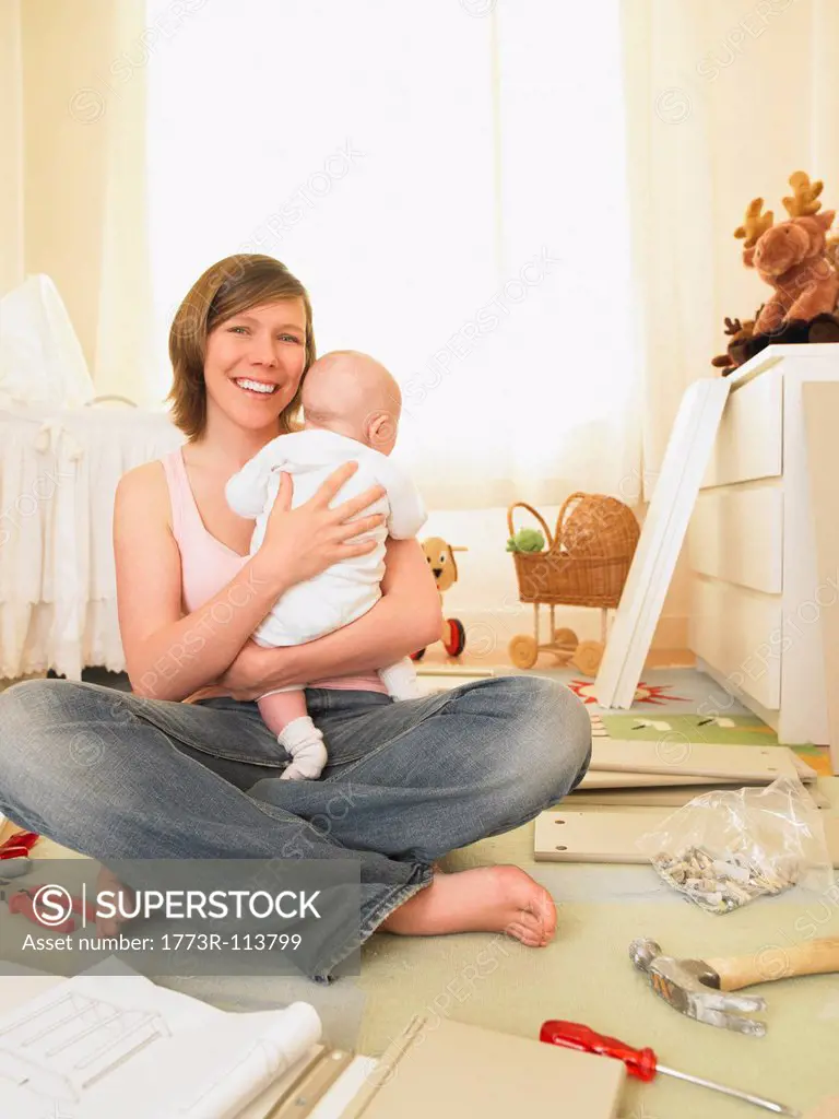 Woman with baby building furniture