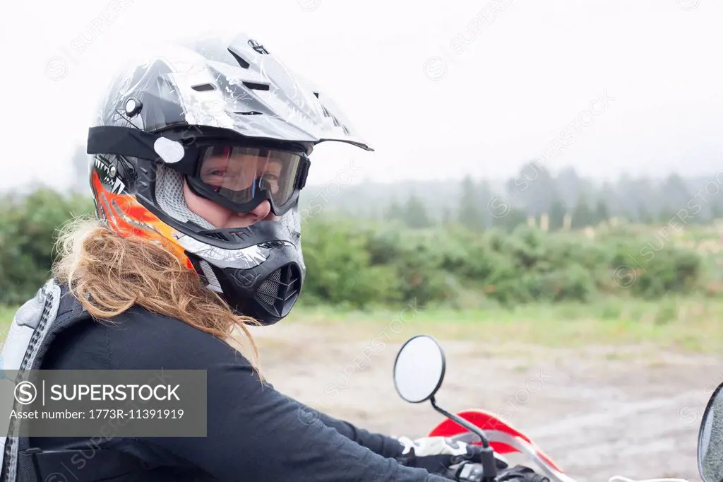 Portrait of mid adult female motorcyclist in crash helmet and goggles