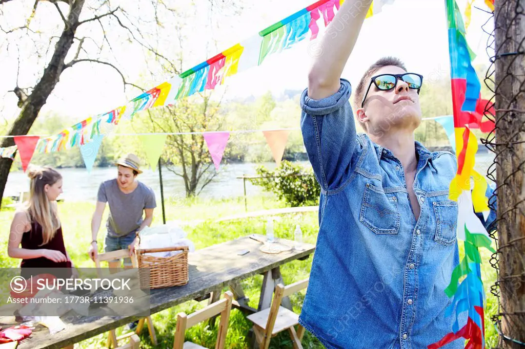 Young man hanging up bunting