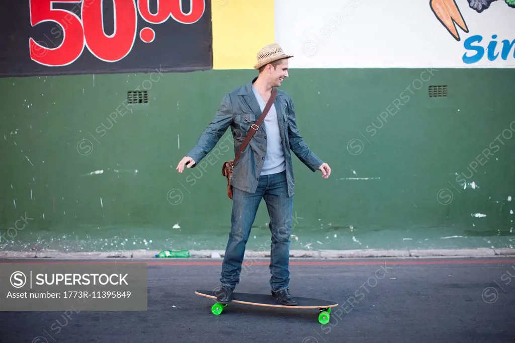 Mid adult male skateboarding on city street
