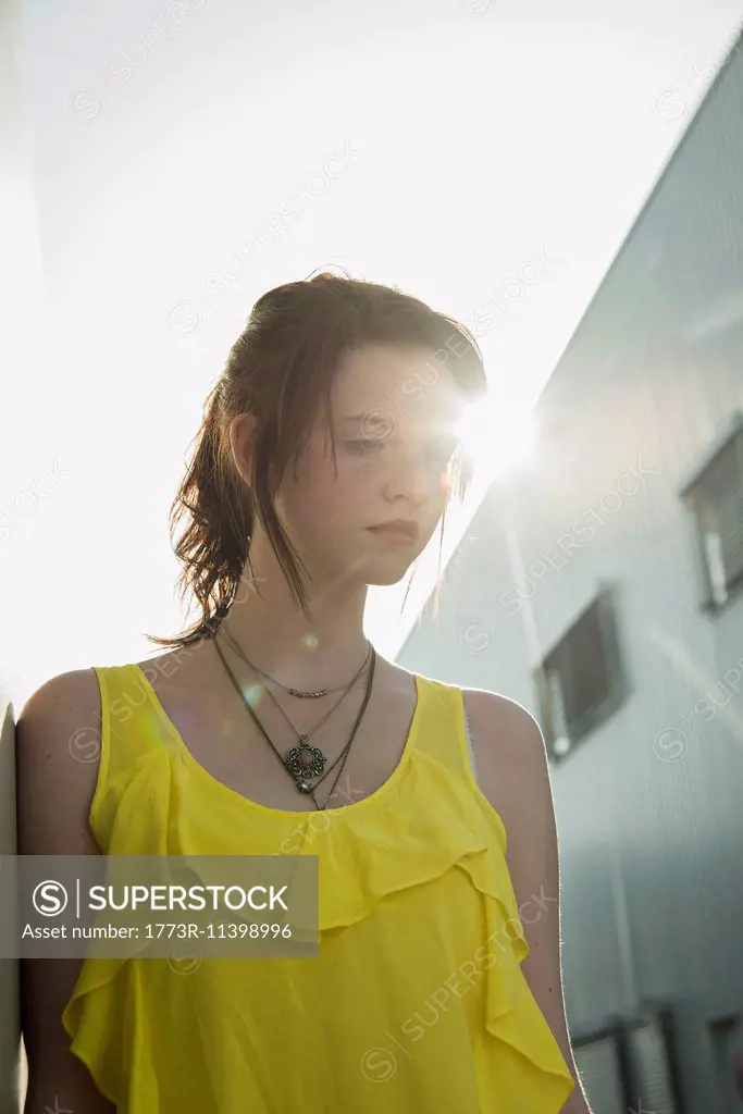 Young sullen girl in yellow blouse gazing down