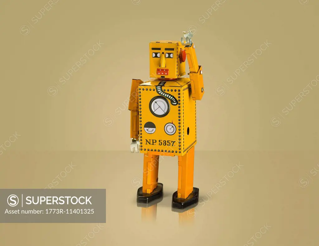 Studio shot of yellow robot with arm raised