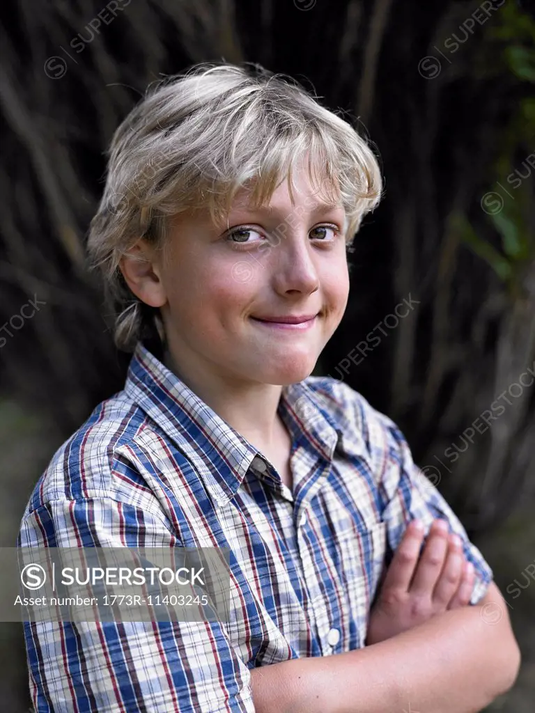 Portrait of smiling boy with arms folded