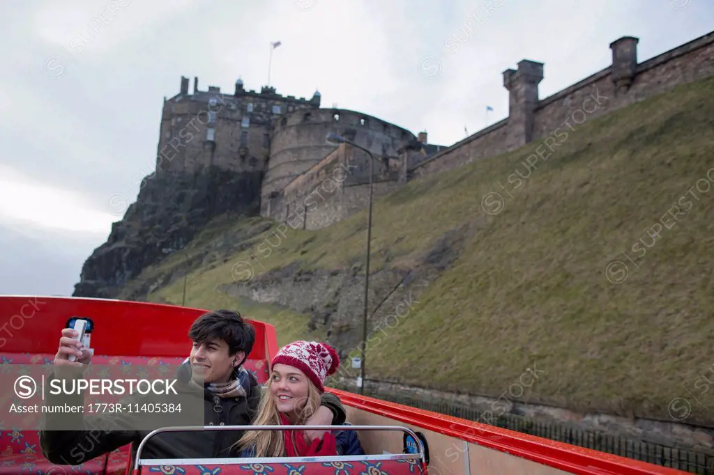 A young couple on an open-top bus tour of Edinburgh Scotland