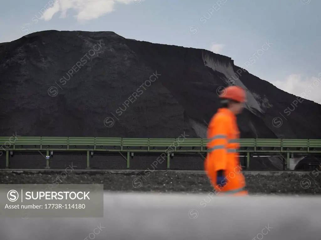 Port Worker With Mound Of Coal