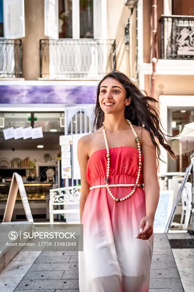 Fashionable young woman strolling down street, Cagliari, Sardinia, Italy