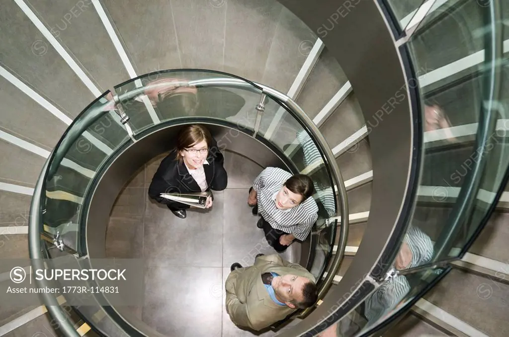 Business trio in a spiral stairwell