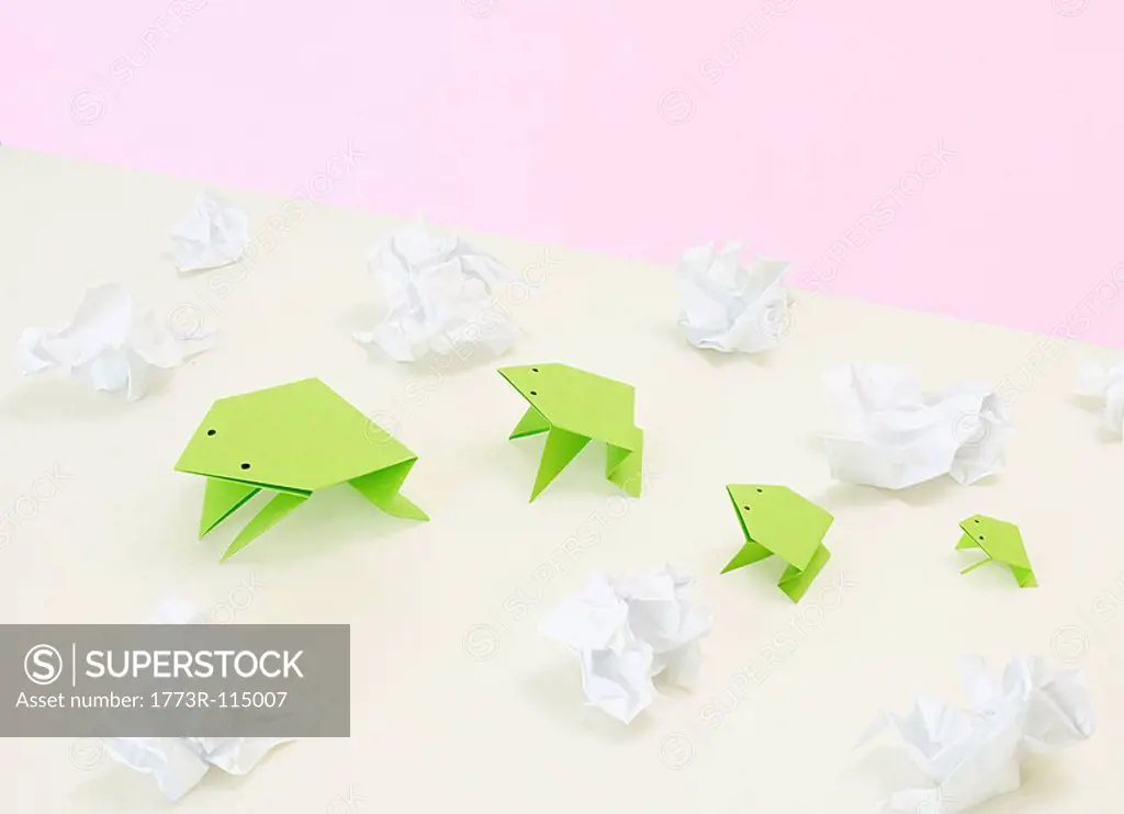 origami frogs amidst scrunched paper