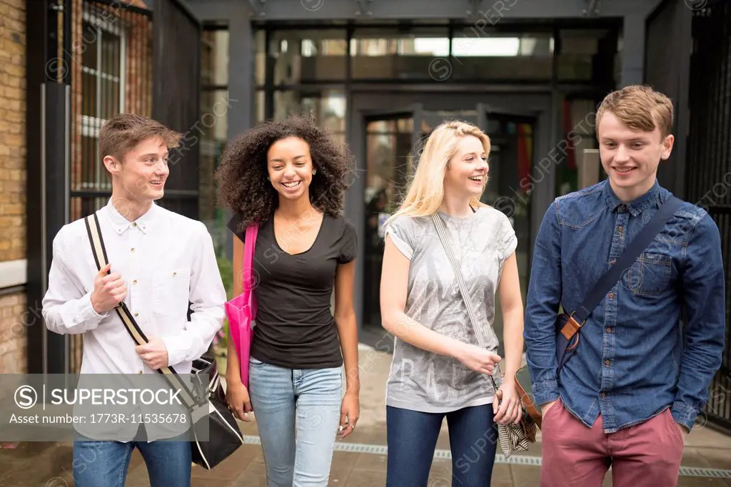Four friends walking and smiling