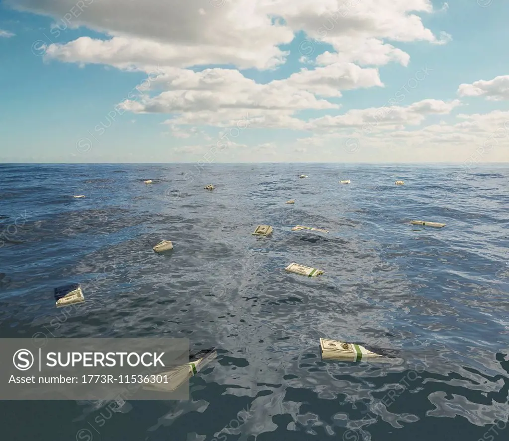 Large group of one hundred dollar bill stacks floating on surface of sea
