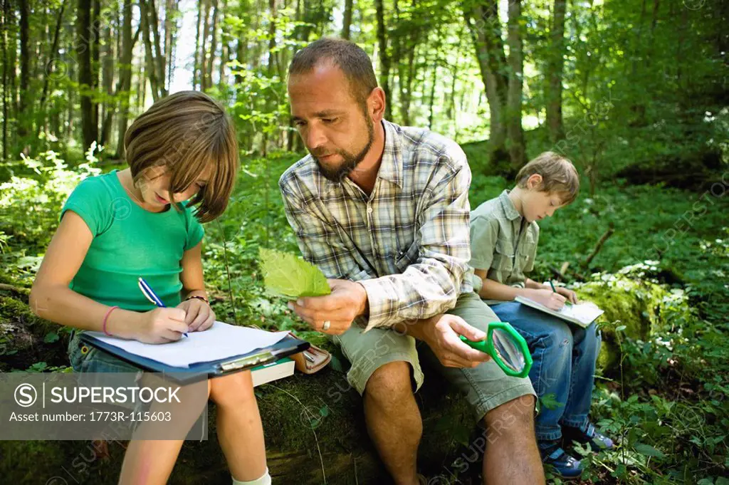 children and teacher in the wood